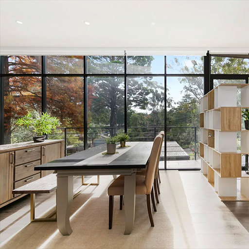 Dining area with full-height glazing overlooking established trees